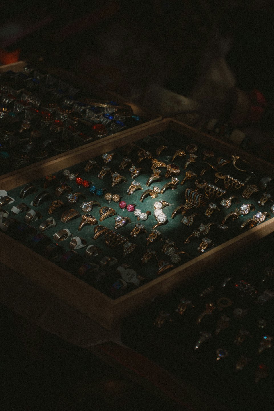Gold rings with colorful gemstones in a velvet tray.
