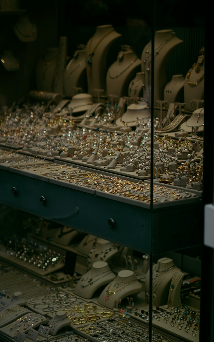Jewelry store display case filled with rings, necklaces, and bracelets.